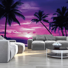 Een fotobehang met een tropische zonsondergang aan zee met palmbomen, zichtbaar in een woonkamer.