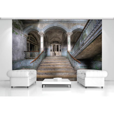 Een fotobehang met een verlaten gebouw met een industriėle trap en ruwe details, ideaal voor een huiskamer.