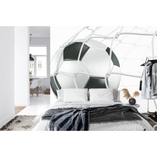 Een fotobehang met een krachtige afbeelding van een voetbal in het doel in een slaapkamer.