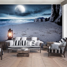 Een fotobehang van een volle maan boven het strand en de zee met een lantaarn te zien in de woonkamer.