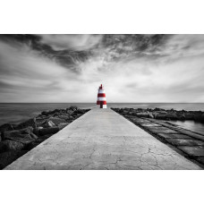 Fotobehang van een vuurtoren op het strand van Praia da Rocha, Algarve, met de zee die tegen de kustlijn klotst.
