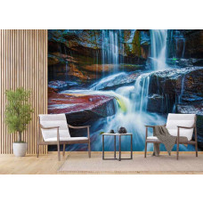 Een woonkamer met fotobehang van een blauwe waterval achter twee fauteuils en een bijzettafel.