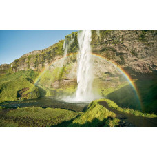 Seljalandsfoss waterval in IJsland met een regenboog in het landschap.