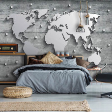 Een fotobehang met een wereldkaart op een achtergrond van beton en zilver voor de slaapkamer.