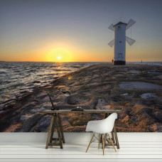 Een fotobehang van zee, strand en een vuurtoren bij zonsondergang, ideaal voor een keuken.