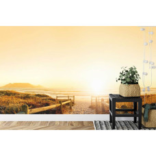 Een sfeervol fotobehang met een zonsondergang op een strandpad, perfect voor een slaapkamer.