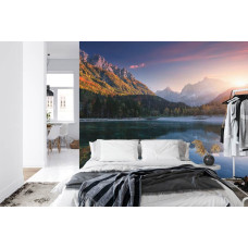 Een fotobehang met een sfeervol bergmeer tijdens zonsondergang in een slaapkamer.