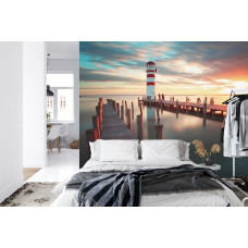 Een fotobehang met een schilderachtige vuurtoren aan zee onder een kleurrijke lucht, perfect voor een slaapkamer.