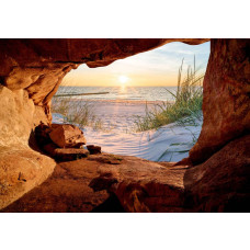 Fotobehang van een zonsondergang boven zee, gezien vanuit een grot met duinen en strand.