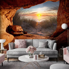 Een fotobehang van een zonsondergang vanuit een grot met een betoverend uitzicht in een moderne woonkamer.