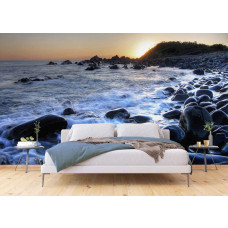Een fotobehang van een zonsopgang bij het kiezelstrand van Forster Zee in een slaapkamer.