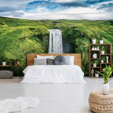 Een fotobehang van een grote waterval in een berglandschap te zien in de slaapkamer.