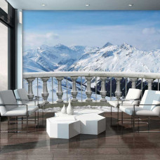 Een fotobehang van een terras met uitzicht op besneeuwde bergen, dat een serene en indrukwekkende sfeer geeft.