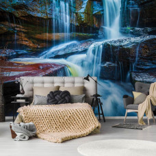 Een fotobehang van een waterval met rotsen voor de slaapkamer.