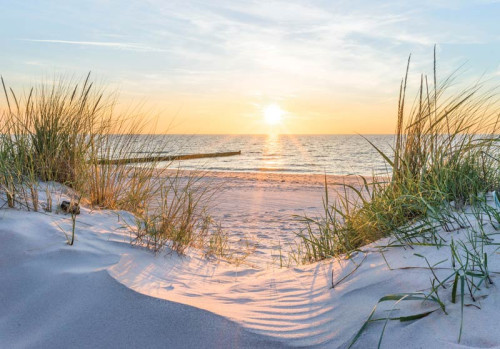 Een prachtige zonsondergang boven een strand en duinen komt tot leven op dit fotobehang, met warme en rustgevende kleuren.