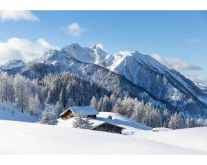 Fotobehang van een besneeuwd berglandschap, waar de bergen oprijzen uit een serene, witte omgeving.