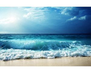 Fotobehang van blauwe golven die het strand bereiken, met een serene en rustige oceaan.