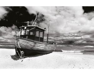 Fotobehang van een schip dat op het strand is aangemeerd, met de golven van de zee op de achtergrond.
