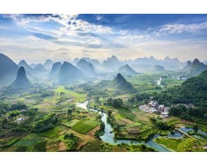 Fotobehang van het karstgebergte in het dorpje Yangshuo, China, met bergen die oprijzen boven een pittoresk landschap.