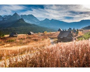 Fotobehang van majestueuze bergen die oprijzen onder een stralende hemel, met een weids uitzicht over de natuur.