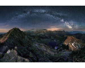 De melkweg die boven bergen en sterren schijnt, prachtig afgebeeld op dit natuurgetrouwe fotobehang.