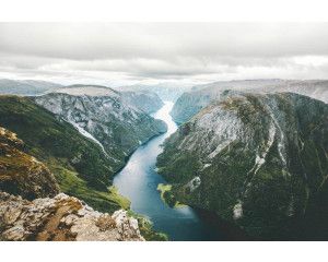 Fotobehang van de Naeroyfjord in Noorwegen, waar de bergen en rivier samenkomen in een ongerept natuurlandschap.