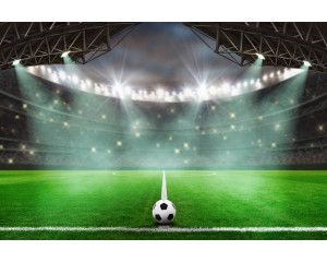 Fotobehang van een voetbal die door de lucht zweeft boven een vol stadion, met tribunes vol enthousiaste toeschouwers.