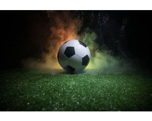 Fotobehang met een magische weergave van een voetbal die door de lucht zweeft, omringd door lichtgevende effecten.