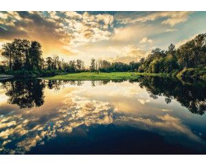 Fotobehang van een zonsondergang aan een meer, landschap in warme tinten.