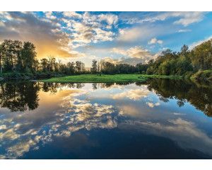 Fotobehang van een meer met spiegeling en reflectie van het landschap.