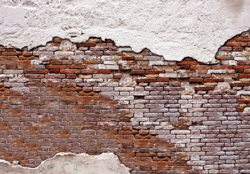 Fotobehang met daarop een oude bakstenen muur met boven en onder cement.